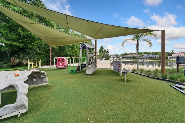 view of jungle gym featuring a lawn and a water view