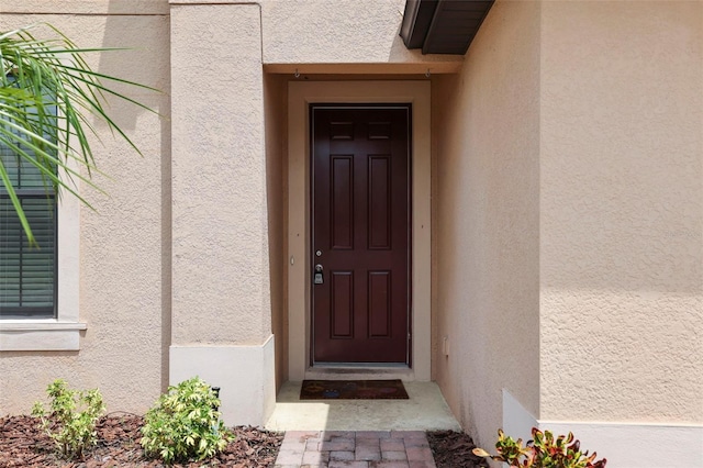 view of exterior entry with stucco siding