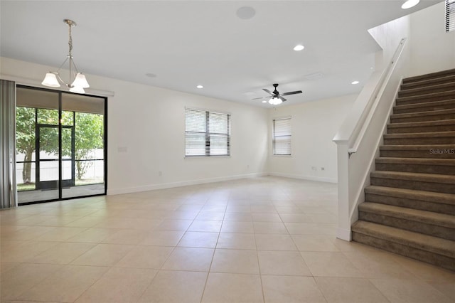 unfurnished living room featuring light tile patterned floors, recessed lighting, ceiling fan with notable chandelier, baseboards, and stairway