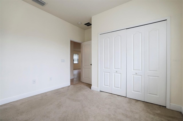 unfurnished bedroom featuring carpet, a closet, visible vents, and baseboards