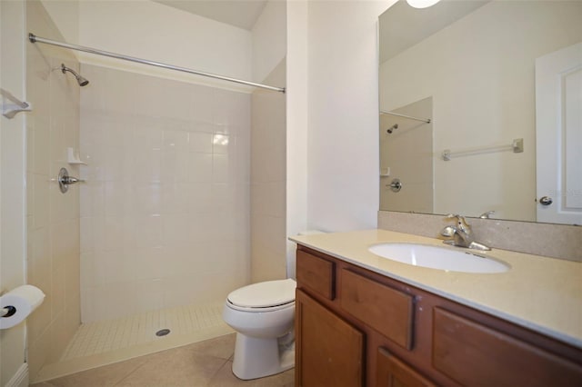 full bathroom featuring a tile shower, vanity, toilet, and tile patterned floors