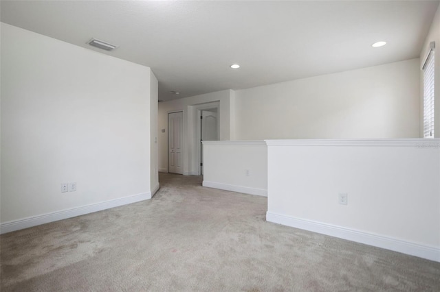 empty room with light colored carpet, visible vents, baseboards, and recessed lighting