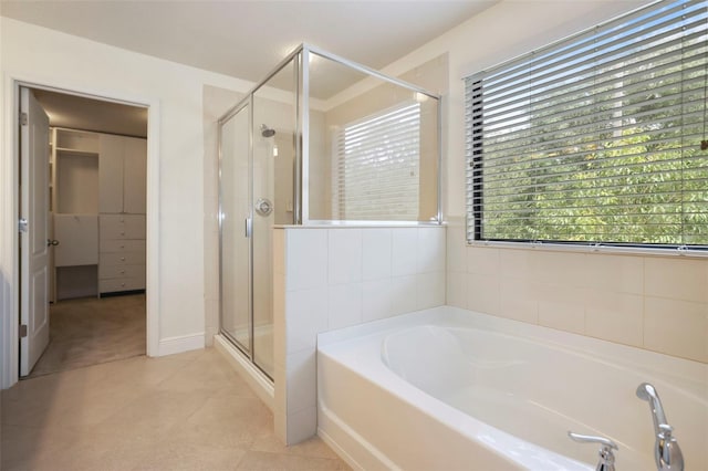 bathroom featuring a garden tub, a shower stall, and tile patterned floors