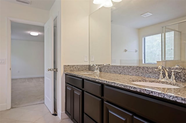 bathroom featuring tile patterned flooring, visible vents, a sink, and double vanity