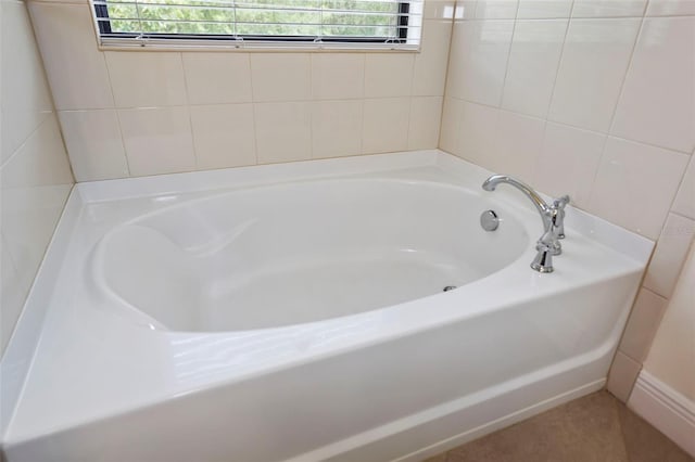 bathroom with a garden tub and a healthy amount of sunlight