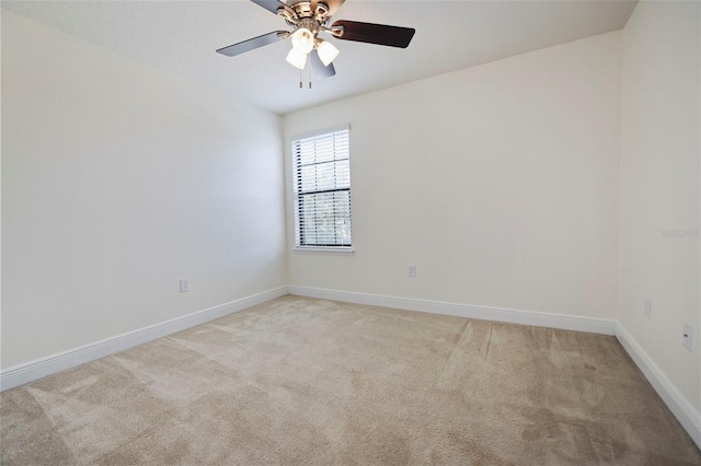 spare room with ceiling fan, baseboards, and light colored carpet