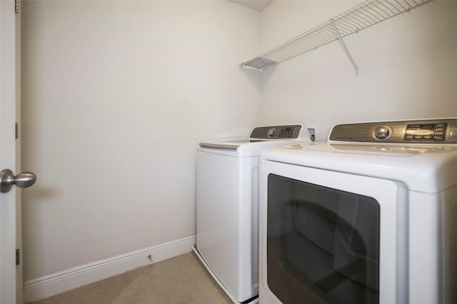 laundry area with laundry area, baseboards, and separate washer and dryer