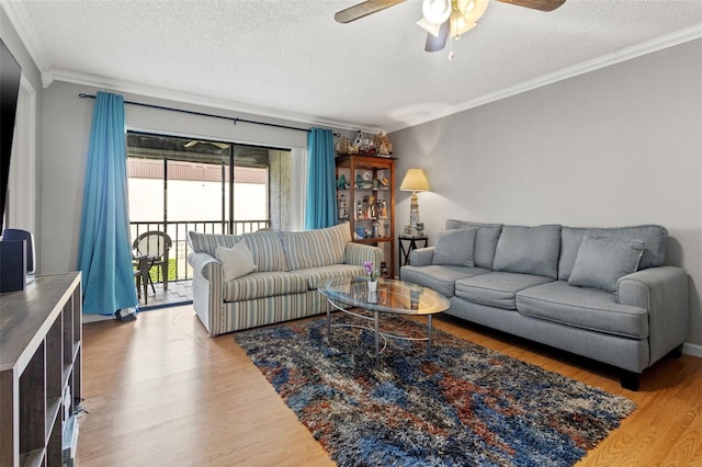 living room with ceiling fan, crown molding, light wood-type flooring, and a textured ceiling