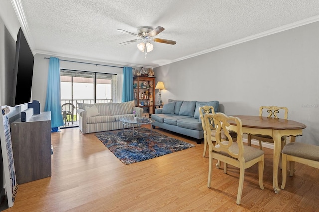 living room with ceiling fan, crown molding, a textured ceiling, and light wood-type flooring