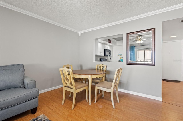 dining area with ceiling fan, ornamental molding, a textured ceiling, and wood-type flooring