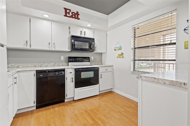 kitchen with light hardwood / wood-style flooring, a tray ceiling, crown molding, black appliances, and white cabinets