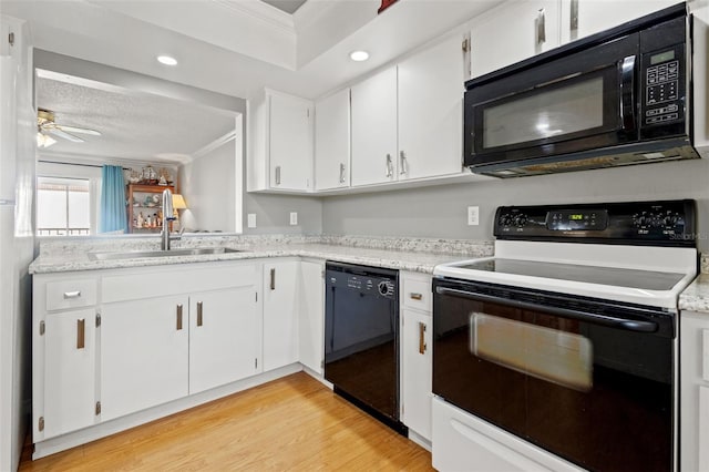 kitchen with sink, light hardwood / wood-style flooring, ceiling fan, black appliances, and white cabinets