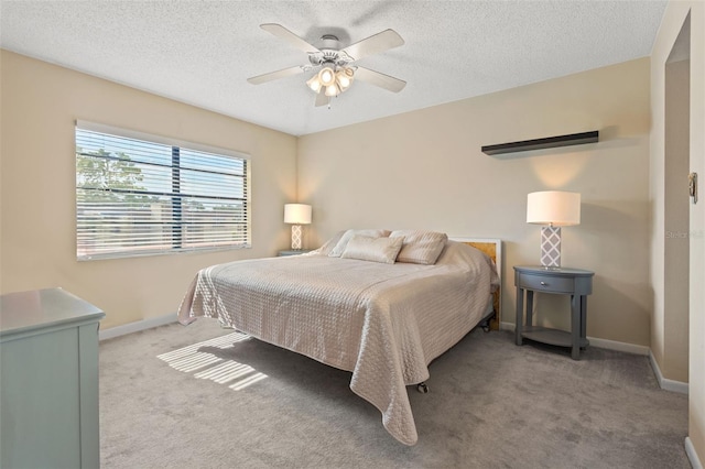 carpeted bedroom with ceiling fan and a textured ceiling