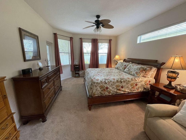 carpeted bedroom featuring ceiling fan and a textured ceiling