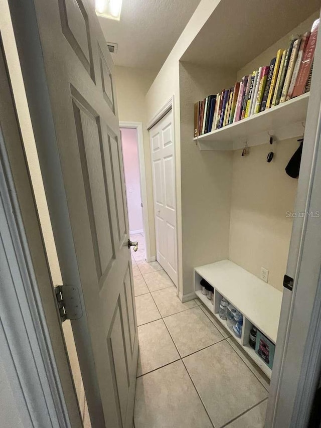 mudroom with a textured ceiling and light tile patterned flooring