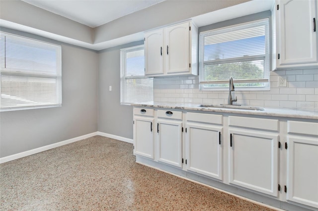 kitchen with white cabinetry, sink, tasteful backsplash, and a healthy amount of sunlight