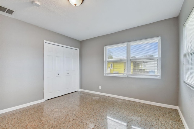 unfurnished bedroom featuring a closet and a textured ceiling