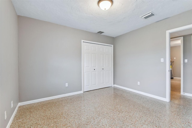 unfurnished bedroom featuring a closet and a textured ceiling