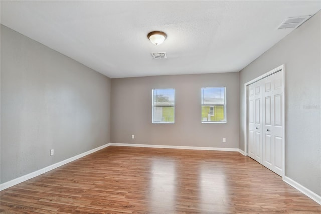 unfurnished bedroom with a closet and hardwood / wood-style floors