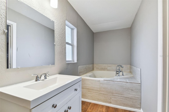 bathroom featuring a bathing tub, vanity, and wood-type flooring