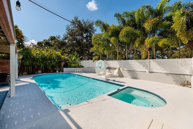 view of swimming pool featuring a patio area and an in ground hot tub