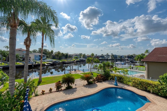 outdoor pool with a yard, a dock, a water view, and boat lift