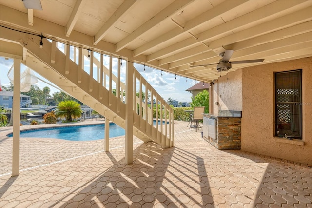 view of swimming pool featuring ceiling fan and a patio area