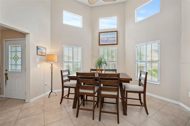 tiled dining space with a towering ceiling