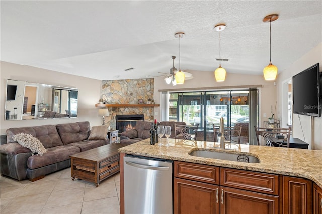 kitchen with dishwasher, light stone counters, brown cabinetry, and a sink