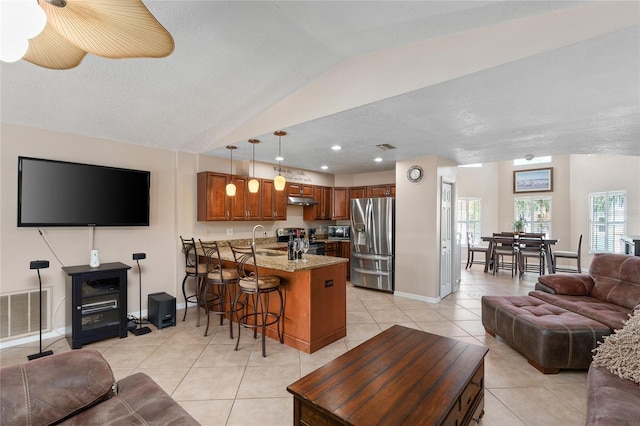 living area with light tile patterned floors, baseboards, visible vents, vaulted ceiling, and recessed lighting