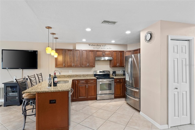 kitchen with a breakfast bar, stainless steel appliances, visible vents, a sink, and a peninsula