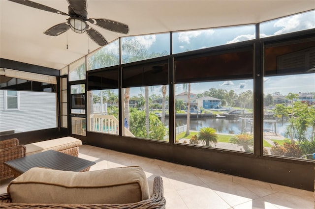 sunroom with ceiling fan, vaulted ceiling, and a water view