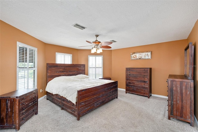 bedroom with multiple windows, ceiling fan, a textured ceiling, and carpet floors