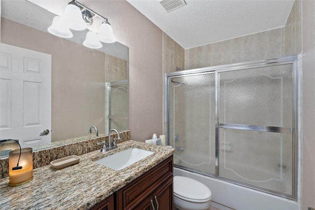 bathroom featuring visible vents, toilet, combined bath / shower with glass door, vanity, and a notable chandelier