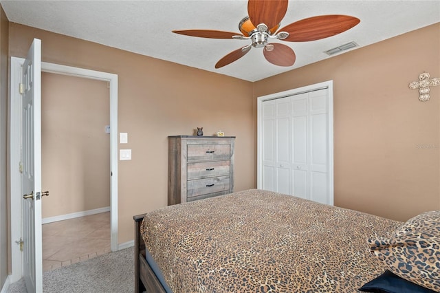 bedroom featuring a textured ceiling, carpet flooring, visible vents, a ceiling fan, and a closet