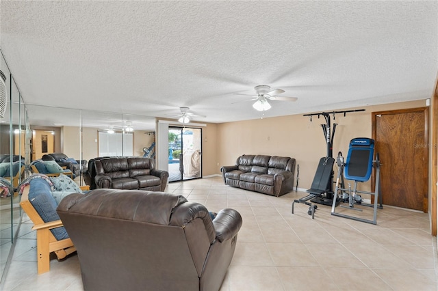 living room featuring light tile patterned flooring, ceiling fan, and a textured ceiling