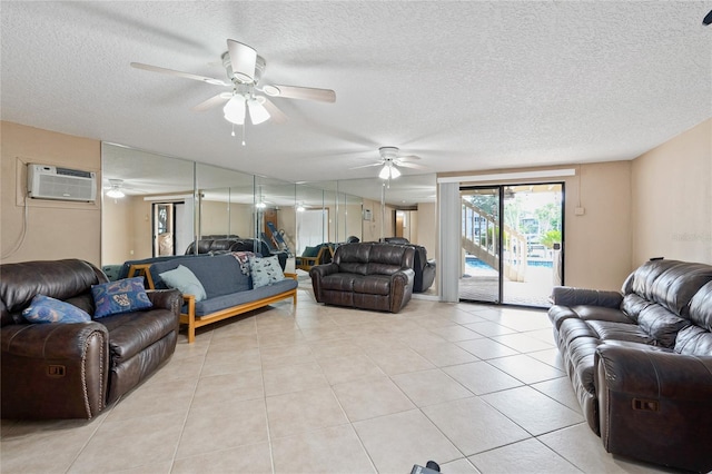 living room with a wall unit AC, ceiling fan, a textured ceiling, and light tile patterned floors