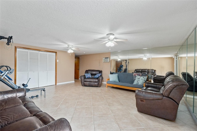 living area featuring ceiling fan, a textured ceiling, light tile patterned flooring, a wall unit AC, and baseboards