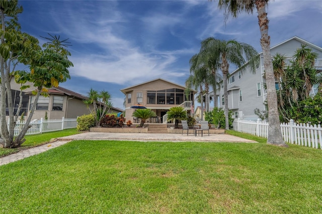 rear view of property with a lawn and a sunroom