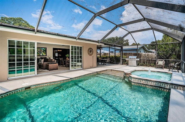 view of pool with a grill, a patio area, glass enclosure, and an in ground hot tub