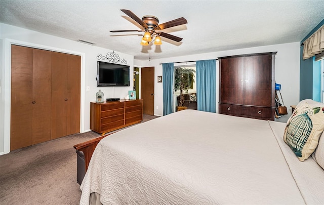 carpeted bedroom with a textured ceiling and ceiling fan