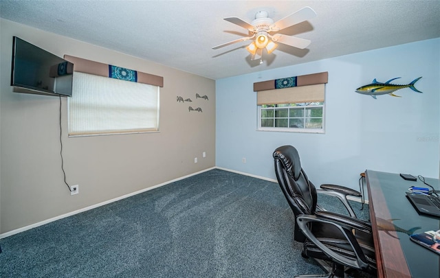 unfurnished office with a textured ceiling, dark colored carpet, and ceiling fan