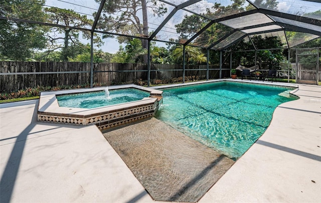 view of swimming pool featuring glass enclosure, a patio area, an in ground hot tub, and pool water feature