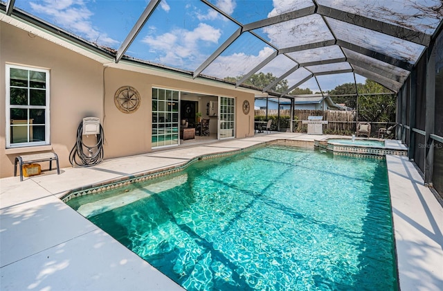 view of swimming pool featuring glass enclosure, an in ground hot tub, and a patio