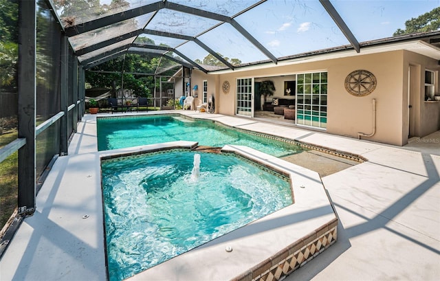 view of pool featuring glass enclosure, an in ground hot tub, and a patio