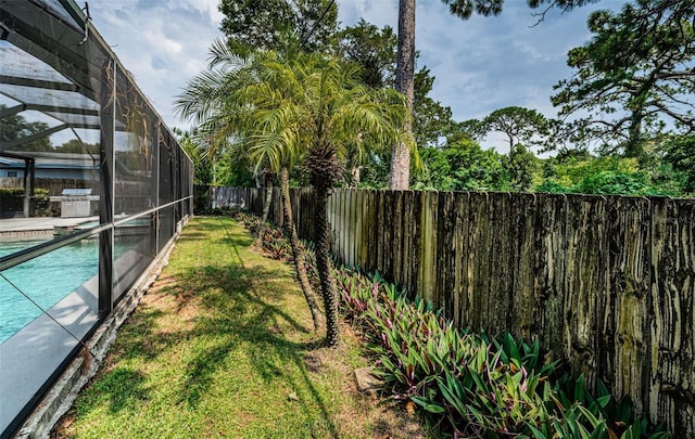 view of yard featuring glass enclosure and a fenced in pool