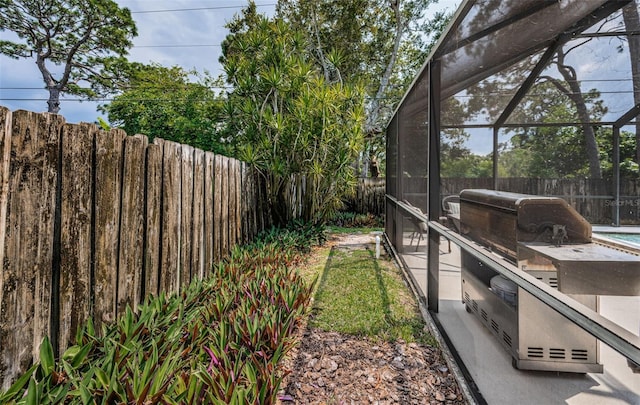 view of yard with glass enclosure