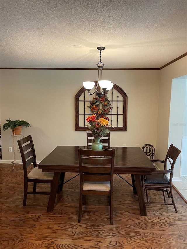 dining area with a textured ceiling, ornamental molding, a chandelier, and hardwood / wood-style flooring