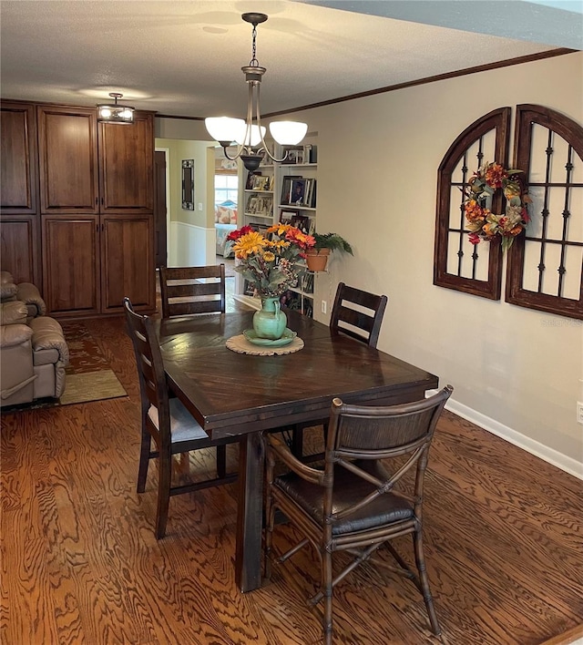 dining area with a textured ceiling, crown molding, dark hardwood / wood-style floors, and an inviting chandelier