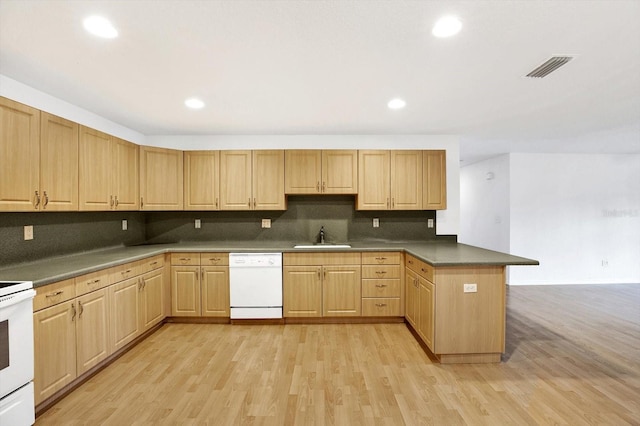 kitchen featuring white appliances, light hardwood / wood-style flooring, kitchen peninsula, and sink